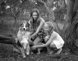 girls and their pet dog border collie with front paw up pose