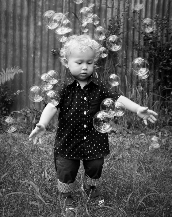toddler boy playing in bubbles at kids photoshoot coorparoo