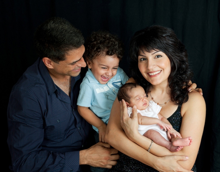 happy family posing with newborn child for photograph Brisbane