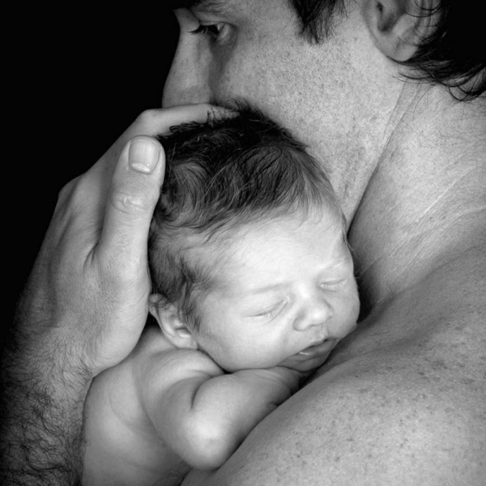 father and newborn baby black and white photography