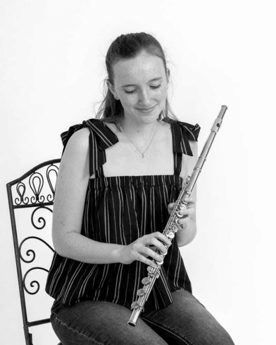 Young musician holds instrument for headshot photograph